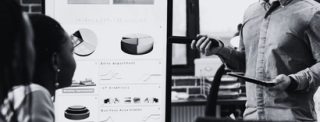 businessman-standing-beside-monitor-showing-manage-JJA5BJG.jpg